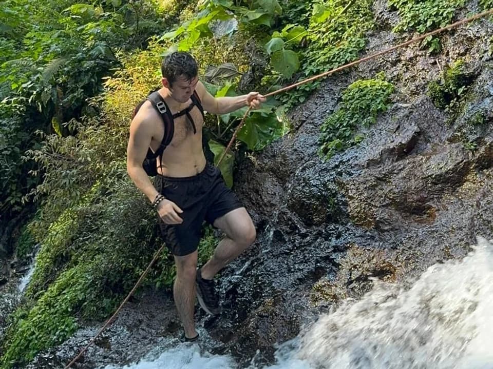 Resting beside a waterfall surrounded by greenery
